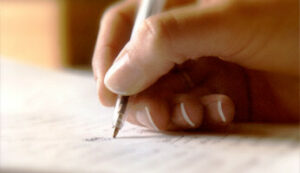 a man writing down notes on a piece of paper