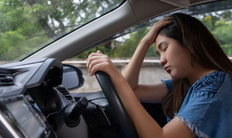 Woman sitting in her car feeling upset